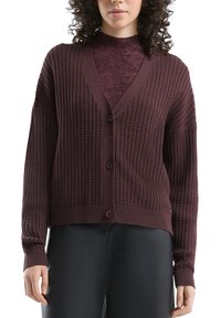 Bordowy kardigan z teksturowanym splotem, dekoltem w serek i guzikami z przodu; ściągacze na mankietach i u dołu; noszony na dopasowanym topie.