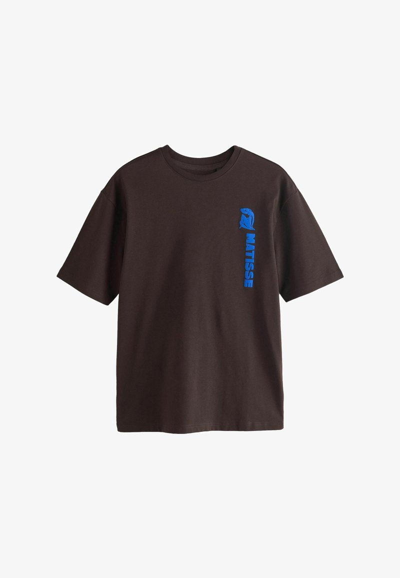 T-shirt à manches courtes marron foncé avec texte vertical bleu "MATISSE" et un graphique bleu abstrait d'une silhouette sur le côté gauche de la poitrine.
