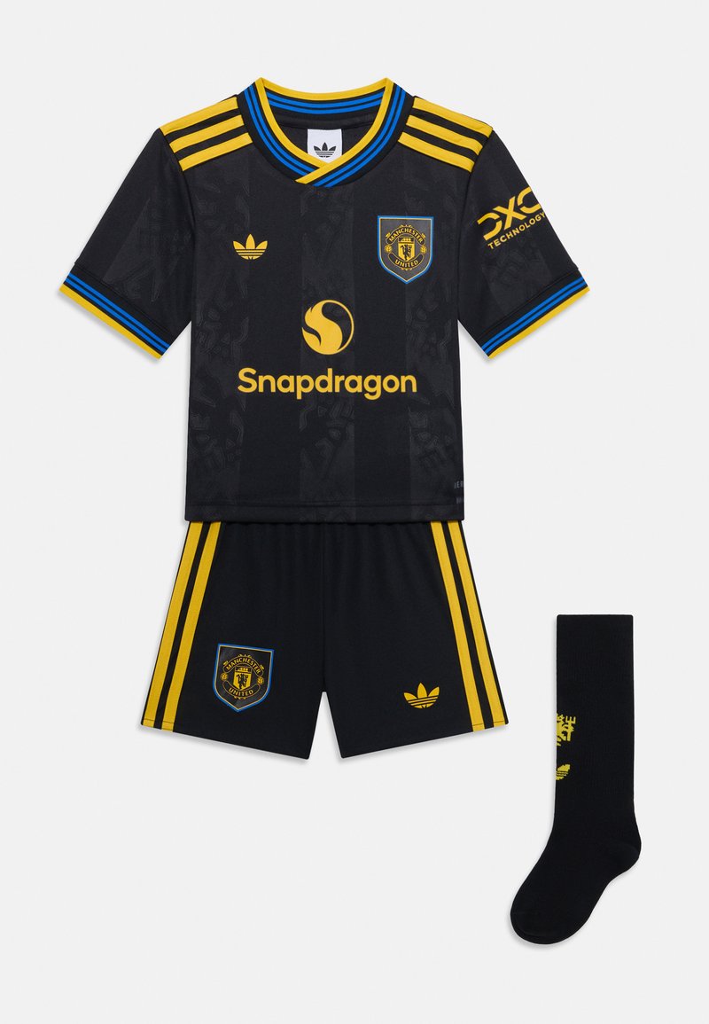 Conjunto de fútbol negro de manga corta con acentos amarillos, que incluye una camiseta estampada, pantalones cortos a juego con logos y calcetas negras con detalles amarillos.