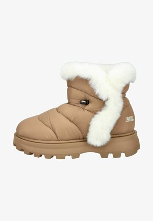 Botte doudoune beige avec finition en fausse fourrure blanche, design rembourré et semelle épaisse présentant des rainures profondes pour une meilleure adhérence. Logo de la marque sur le côté.