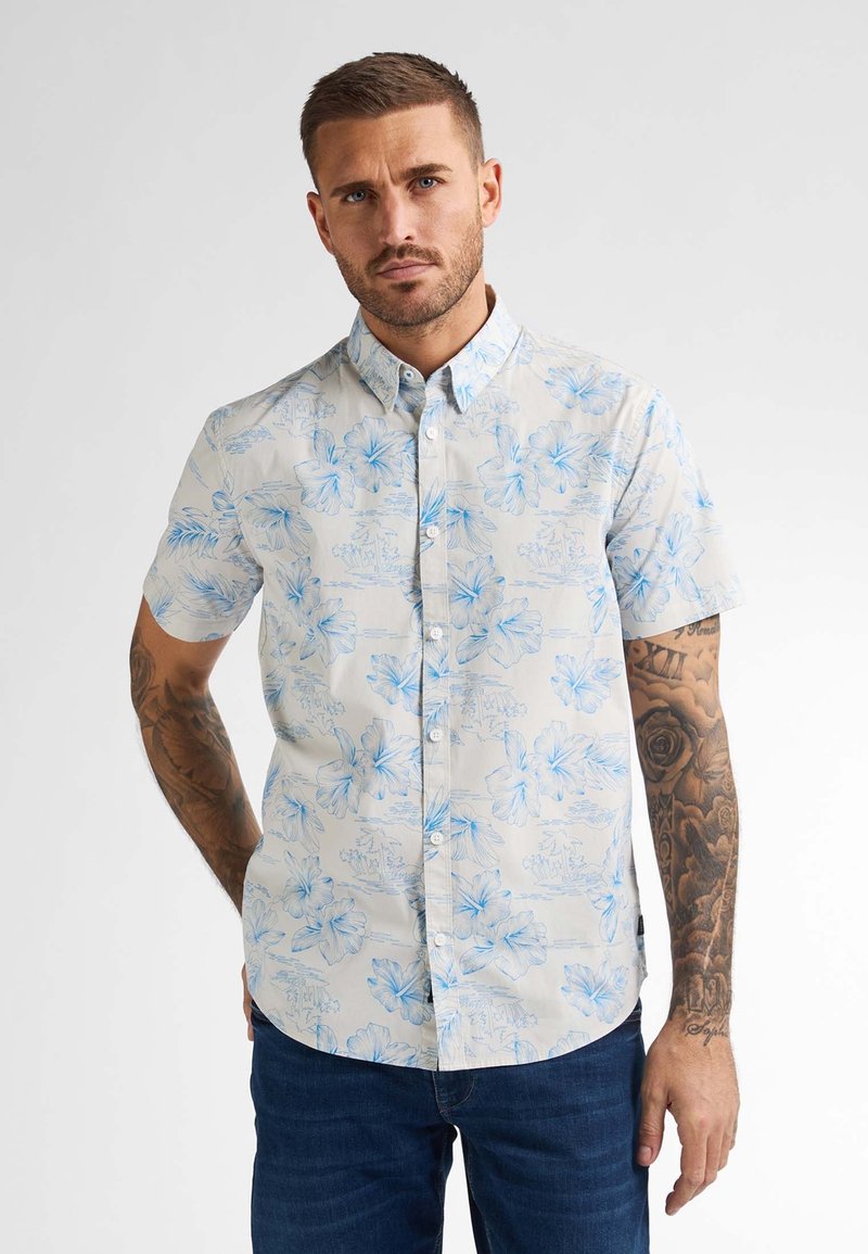 Korte mouw blouse van lichte stof, met een lichte achtergrond en blauwe bloemenpatronen, en een doorgeknoopte kraag.