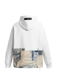 Sudadera blanca con un diseño de bolsillo de mezclilla en patchwork en la parte baja de la espalda y una etiqueta negra en la capucha.