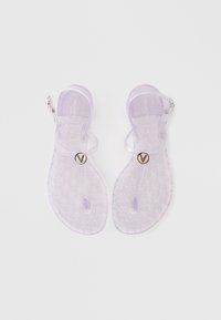 Gennemsigtige lavendel sandaletter med et præget mønster. Har en rem med en sølvspænde og en cirkulær logo-accent. Flad sål design.