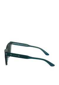 Occhiali da sole turchesi con montatura in plastica trasparente, lenti scure, aste dritte e sottili dettagli in argento sui lati.