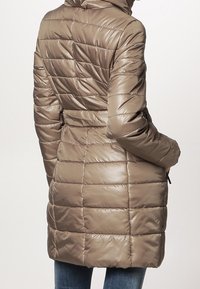 Jasnobrązowy, ocieplany zimowy płaszcz z kapturem, z paskiem w talii, pionowym pikowaniem i gładką, błyszczącą teksturą.