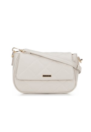 Sac à bandoulière matelassé beige avec quincaillerie dorée, fermeture à rabat et bandoulière réglable, plaque logo métallique de marque sur le devant.