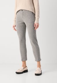 Grijs houndstooth-patroon pantalon met een slim fit, voorzien van een knoopsluiting aan de voorkant en zijzakken, gecombineerd met lichtroze loafers.