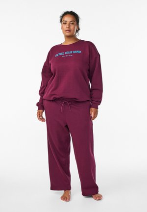 Bordeauxfarbener Sweat-Set mit Rundhalsausschnitt und langen Ärmeln, versehen mit einem blauen "DETOX YOUR MIND"-Textgrafik. Lockere Hose mit Zugband.