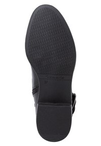 Suela de zapato sintética negra con una superficie texturizada, presenta un ligero tacón y un logotipo de marca en relieve. Tamaño 37 indicado.