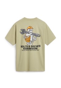 Camiseta verde oliva con una gráfica de un esqueleto con una cerveza y una llave inglesa. El texto dice "BOLTS & BREWS" y "VANS 'OFF THE WALL'."