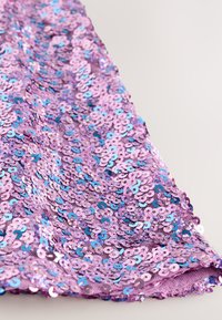 Fialová flitrová tkanina s kruhovými, lesklými flitrami v rôznych odtieňoch modrej a ružovej, vytvárajúca textúrovaný, reflexný povrch.