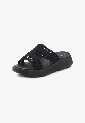 Black slide sandals featuring a textured upper with mesh design, a cushioned sole, and an open-toe style for breathability.