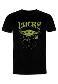 Sort T-shirt med et grønt grafik af en figur med store ører og teksten "LUCKY" ovenfor, sat imod et burst-mønster.