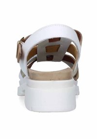 Sandalo bianco con una finitura liscia e lucida, dotato di una fascia regolabile e di una soletta beige. Suola chunky bianca con una superficie testurizzata.