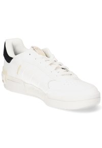 White leather sneaker with black suede heel, textured sole, perforated toe, and three embossed stripes. Features a cushioned insole.