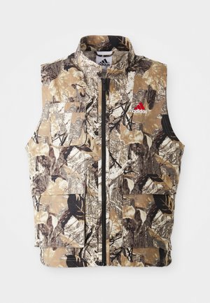 Gilet sans manches à motif camouflage dans des tons terreux de marron, beige et noir. Doté d'une fermeture éclair à l'avant et de plusieurs poches cargo. Détail logo rouge.