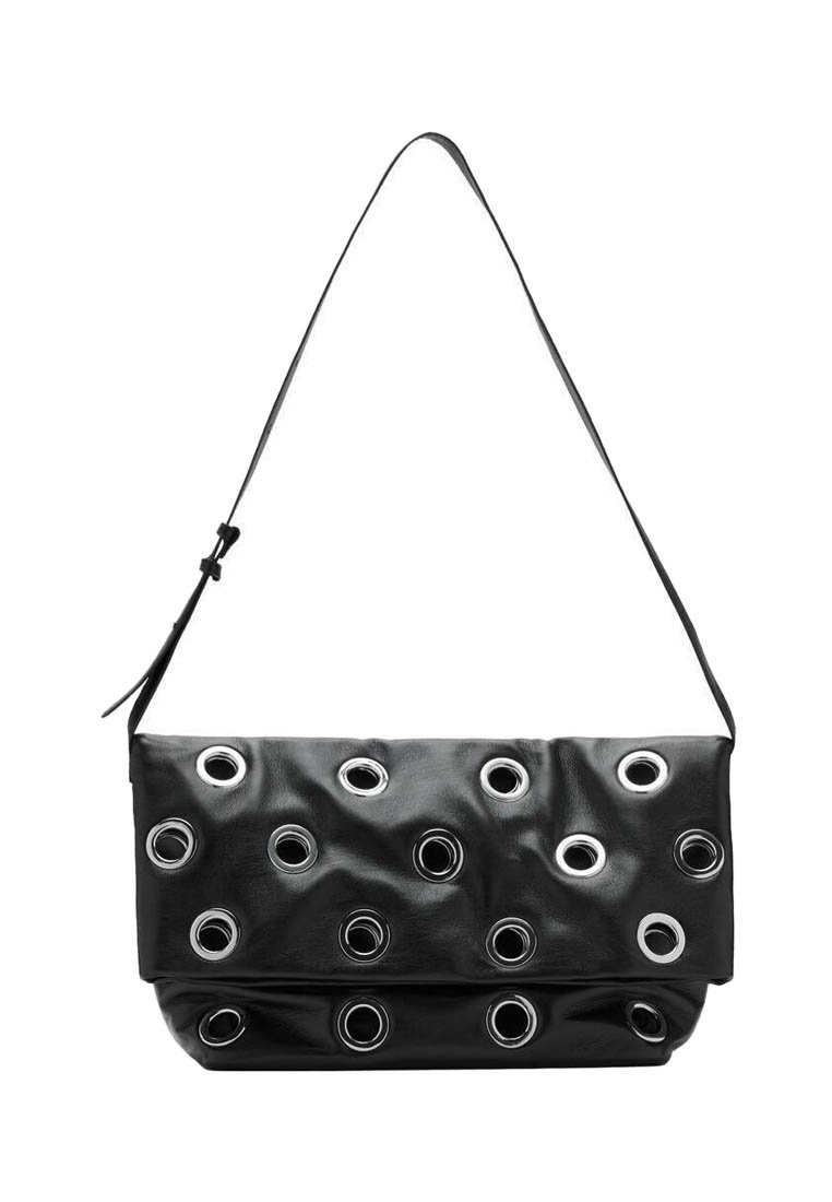 Bolso de cuero negro con múltiples ojales plateados, diseño plegable y una sola correa para llevar. Textura suave con una apariencia blanda.