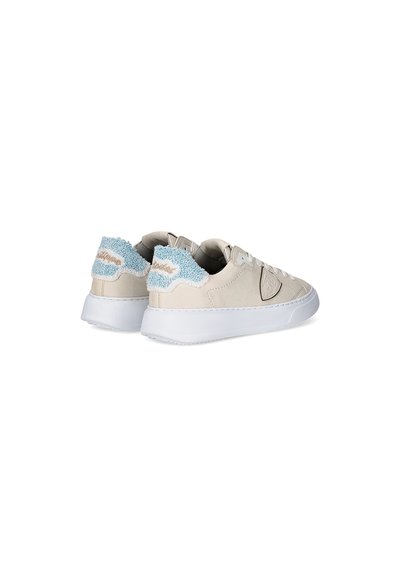 Sneakers beige con un accento in tessuto testurizzato blu chiaro sul tallone. Suola in gomma bianca, design elegante e lacci tonali completano il look.