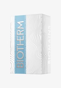 Biały pojemnik z wypukłym falistym wzorem, z niebieską etykietą. Tekst zawiera "BIOTHERM" w kolorze srebrnym. Czysty, nowoczesny design.