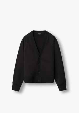 Juodas megztinis iš minkštos medžiagos, turintis V formos iškirpę, raglanines rankoves, priekinį mygtukų uždarymą ir nertus manžetus bei apatinę dalį. Minimalus logotipo detalė.