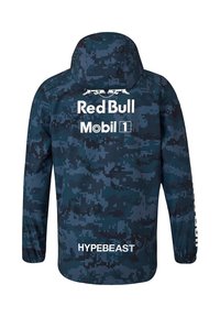 Granatowa kurtka w kamuflażu z kapturem. Posiada białe loga Red Bull i Hypebeast z tyłu, wykonana z lekkiego materiału.