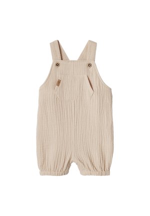 Beige cotton toddler romper with front pocket, adjustable button straps, and elasticized leg openings.