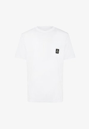 T-shirt en coton blanc avec un col rond et des manches courtes. Détail notable : un petit écusson noir sur la poche poitrine gauche.