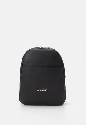 Mochila negra Valentino hecha de cuero texturizado con cremallera dorada y bolsillo frontal sobre un fondo blanco liso.