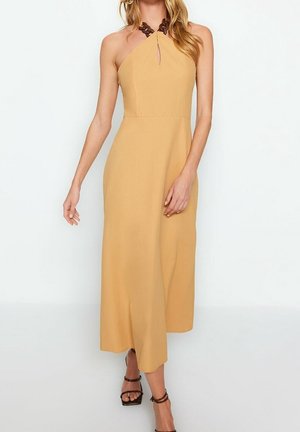 Senfgelbes Maxikleid mit Halterneck-Design, das eine Aussparung in Tropfenform und dunkelbrowne Akzente am Ausschnitt aufweist. Glatte Textur.
