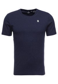 Granatowa koszulka z krótkim rękawem wykonana z miękkiej bawełny, z okrągłym dekoltem i małym logo na lewej piersi. Prosty design, bez wzorów.