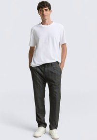 White short-sleeve t-shirt and dark gray trousers with a subtle check pattern, finished with white sneakers, relaxed fit.