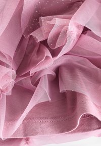 Hellrosa Tüllstoff mit einer weichen, transparenten Textur, verziert mit zarten goldenen Sprenkeln und gerafften Kanten, geschichtet und zerknittert.