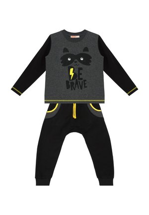 Ensemble deux pièces pour enfant avec manches longues noires et pantalon, devant gris avec visage de raton laveur, éclair jaune et texte ""Be Brave"".