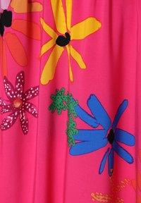 Tissu rose vif avec de grands motifs floraux colorés en jaune, orange, vert et bleu. Présente des formes audacieuses et des accents noirs.