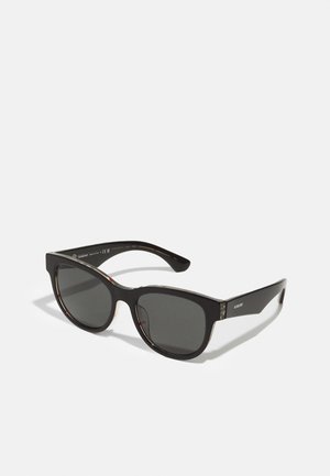 Gafas de sol negras con forma rectangular, lentes oscuros, acabado brillante y sutiles acentos de carey en el interior de las varillas.