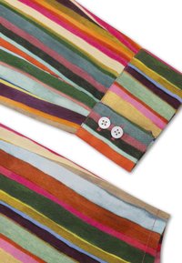 Multikleurige gestreepte shirtmanchet met horizontale banden in tinten groen, roze, oranje en blauw, met twee witte knopen en contrasterende stiksels.