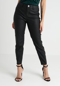 Černé kalhoty z umělé kůže s vysokým pasem a přiléhavým střihem, vybavené předním zapínáním na knoflíky a dvěma bočními kapsami. Hladká textura.