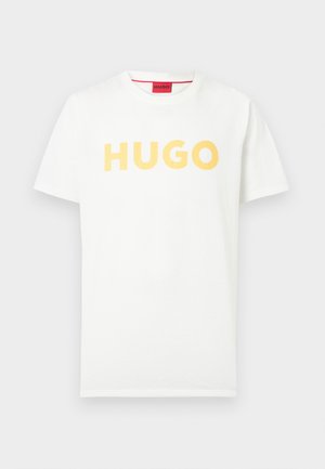 Hvid T-shirt med korte ærmer og gul "HUGO"-tekst centreret på brystet samt en rød label synlig inde i kraven.