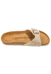 Ljus beige slide-sandal med ett justerbart band, prydd med en spänne och en texturerad korkfotbädd. Logotyp tryckt på innersulan.