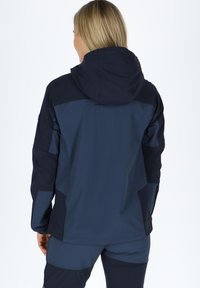 Dark blue jacket made of waterproof material, featuring a hood, contrasting panels, and side pockets, designed for outdoor activities.