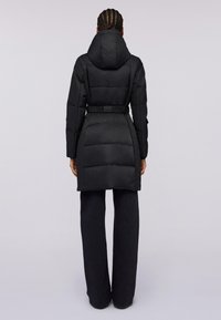 Svart vadderad jacka med huva och bälte i midjan. Har en kviltad textur och en skräddarsydd passform som sträcker sig till mitten av låret.