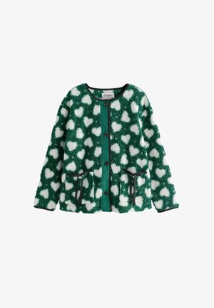 Žalias fliso megztinis su baltomis širdelėmis, turintis mygtukų užsegimą, juodą apdailą ir dvi priekinės kišenes. Minkšta, tekstūruota medžiaga.