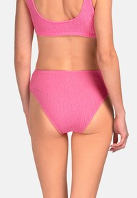 Różowe majtki bikini z wysokim stanem, wykonane z teksturowanej tkaniny, z falistym wzorem i bezszwowym wykończeniem dla gładkiego dopasowania.