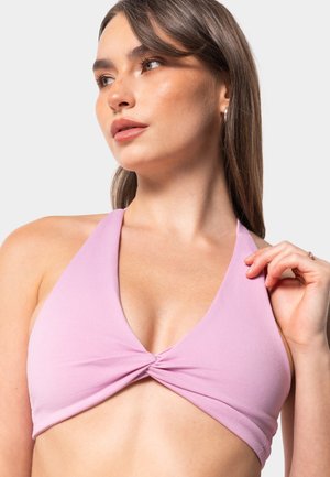 Lilac halter top bikini with a twisted front design, soft texture, and minimal hardware. Features wide straps and a plunging neckline.