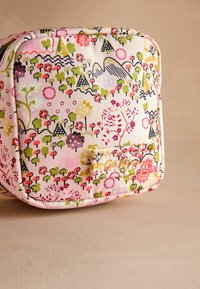 Õiguslik kott, millel on lille- ja geomeetriline muster roosa, rohelise ja musta värviga heledal taustal. Sisaldab logoplaati.