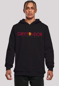 Fekete kapucnis pulóver, piros és sárga "GRYFFINDOR" felirattal és oroszlán emblémával. Az anyag puha, elülső zsebbe és bordás mandzsettákba öltöztetve.