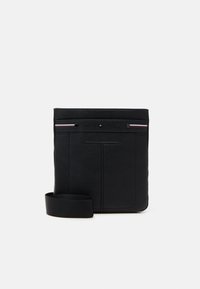Must mustaga mantli nahkõlest crossbody kott, millel on tekstuurne viimistlus, esitades logo ees ja eemaldatav kangastrap. Minimalistlik disain peente aktsentidega.