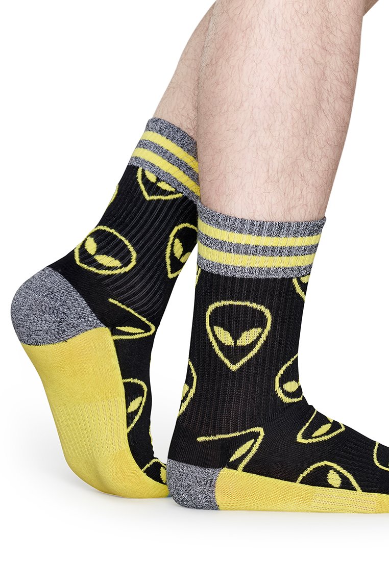 Czarne skarpetki z żółtymi ikonami obcych i szarymi akcentami. Żebrowana tekstura, żółte części palców i pięt oraz szary prążkowany mankiet na górze.