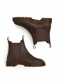 Botas de tobillo de cuero marrón con paneles laterales texturizados, tiradores y una suela de goma gruesa con un patrón acanalado.