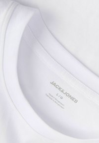 Col de t-shirt blanc Jack & Jones indiquant la taille L et "Made in Bangladesh" imprimé à l'intérieur de l'encolure.